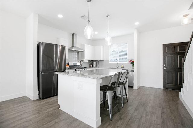 kitchen featuring stainless steel appliances, dark wood-type flooring, a kitchen island, decorative backsplash, and wall chimney exhaust hood