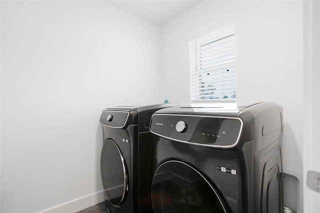 laundry room featuring laundry area, washing machine and clothes dryer, and baseboards