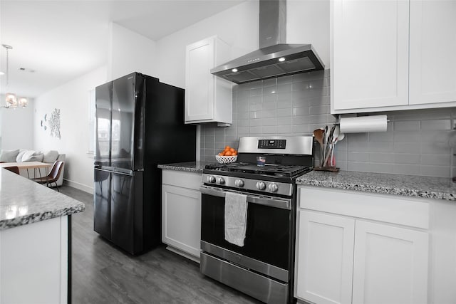 kitchen with freestanding refrigerator, white cabinets, stainless steel range with gas stovetop, and wall chimney exhaust hood