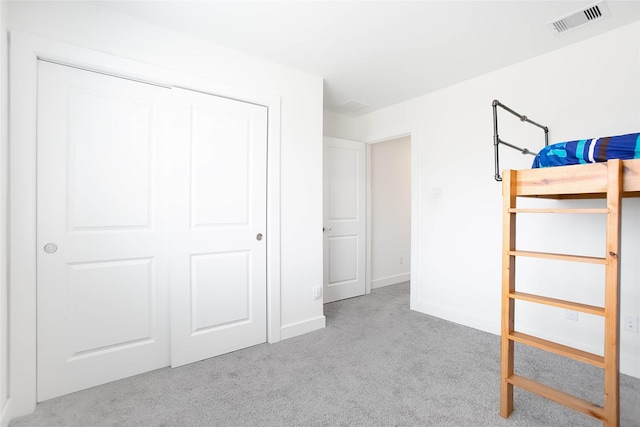 unfurnished bedroom with baseboards, a closet, visible vents, and carpet flooring