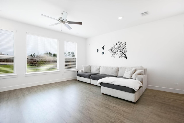 living area with a ceiling fan, baseboards, visible vents, and wood finished floors