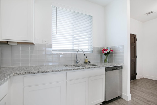 kitchen featuring visible vents, white cabinets, a sink, light wood-type flooring, and dishwasher