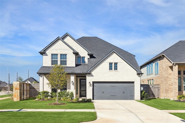 view of front of home featuring a front yard, fence, concrete driveway, and brick siding