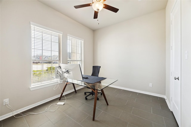 office featuring dark tile patterned floors, a ceiling fan, and baseboards