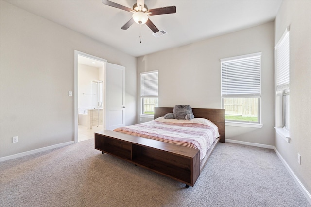 bedroom featuring carpet floors, visible vents, a ceiling fan, ensuite bath, and baseboards