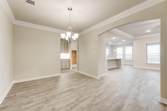 empty room with light wood-type flooring, arched walkways, visible vents, and crown molding