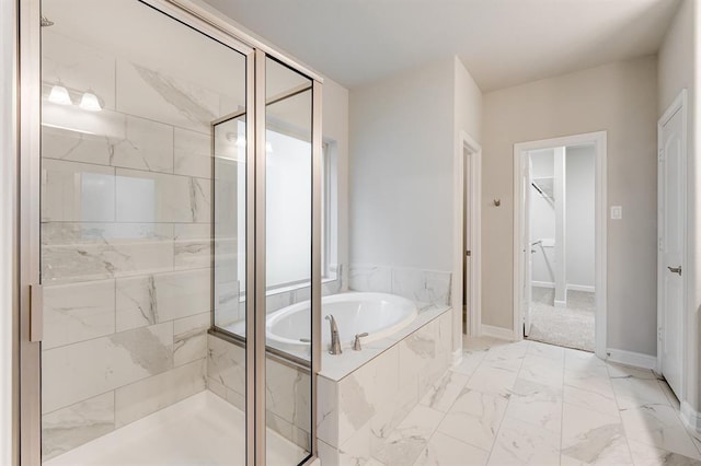 bathroom with a garden tub, a shower stall, marble finish floor, and baseboards