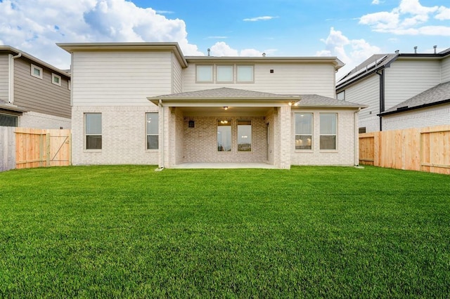 back of house with a fenced backyard, a patio, and a yard