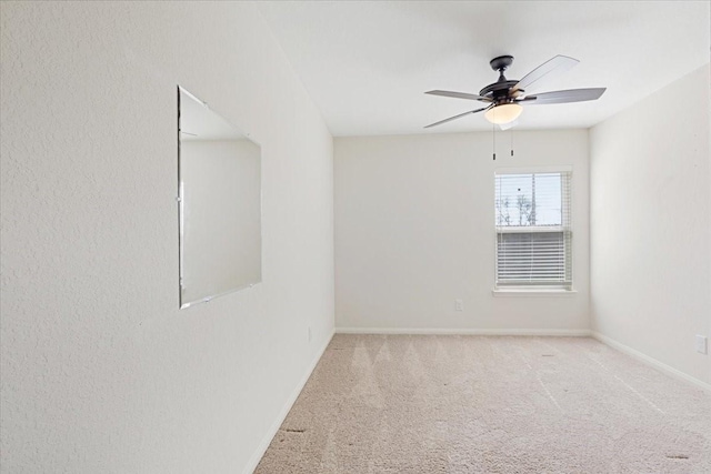 unfurnished room featuring carpet flooring, a ceiling fan, and baseboards