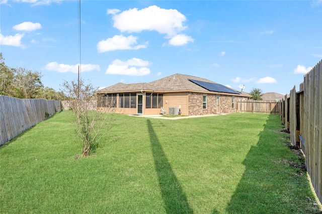 view of yard featuring a sunroom, a fenced backyard, and central air condition unit