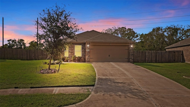 view of front of home with brick siding, a yard, concrete driveway, fence, and a garage