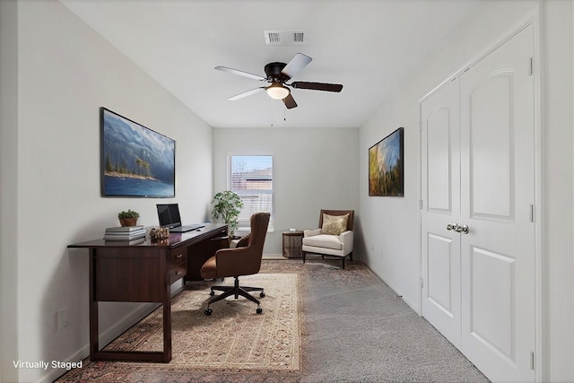 carpeted office space featuring ceiling fan, visible vents, and baseboards