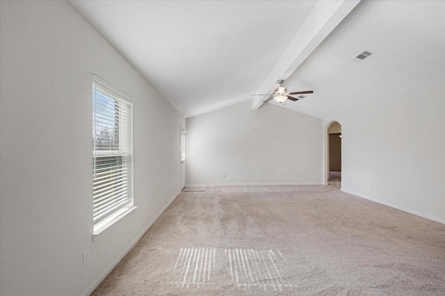 empty room with arched walkways, visible vents, lofted ceiling with beams, light carpet, and ceiling fan