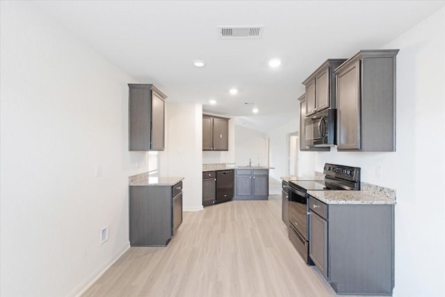 kitchen with light wood finished floors, recessed lighting, visible vents, a sink, and black appliances