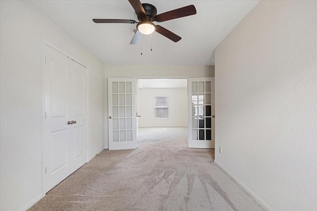 unfurnished room with ceiling fan, french doors, carpet, and baseboards