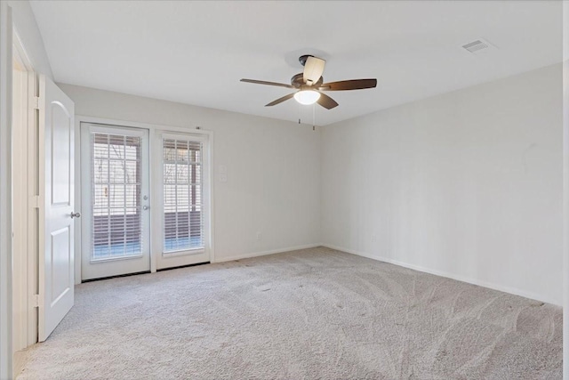 carpeted spare room featuring ceiling fan, french doors, visible vents, and baseboards