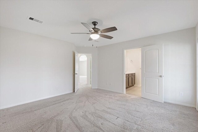 empty room featuring baseboards, ceiling fan, visible vents, and light colored carpet