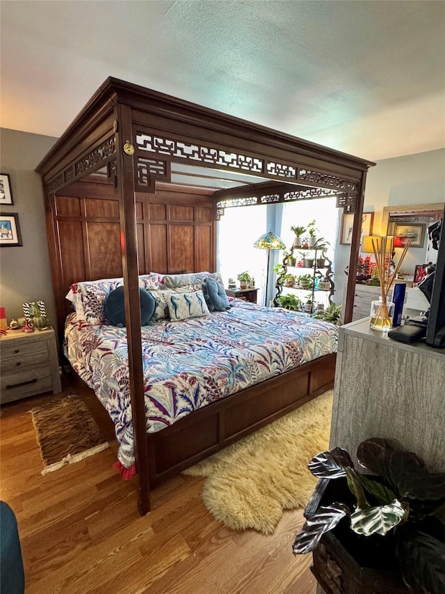 bedroom with access to outside and wood finished floors