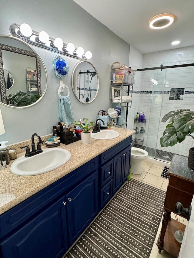 bathroom featuring double vanity, tile patterned flooring, a sink, and a shower stall