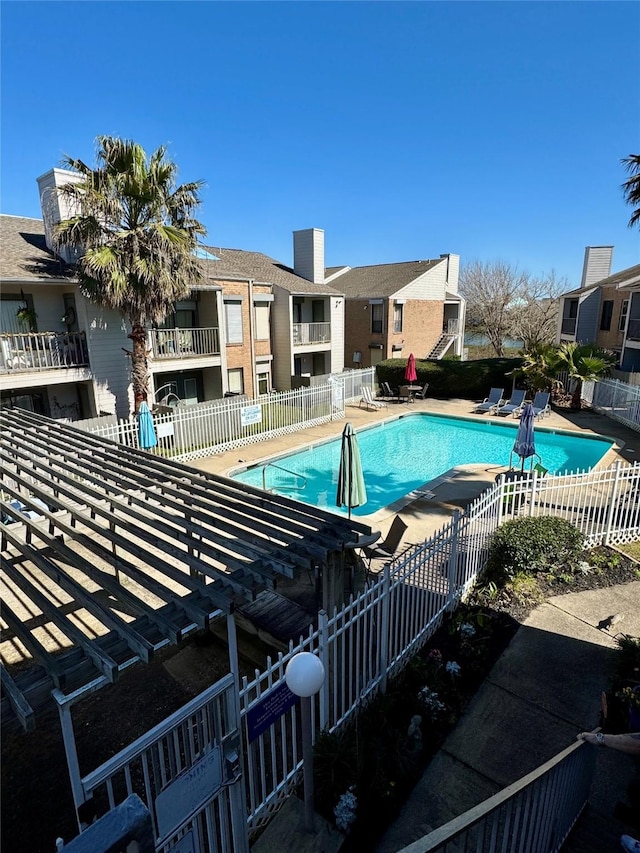 pool with a patio area and fence