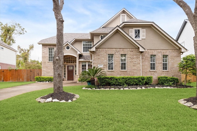 view of front of home featuring stucco siding, fence, and a front yard