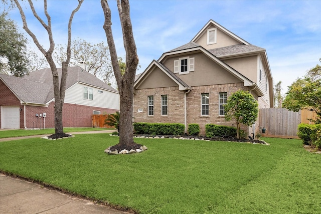 traditional-style home with a front yard, brick siding, fence, and stucco siding