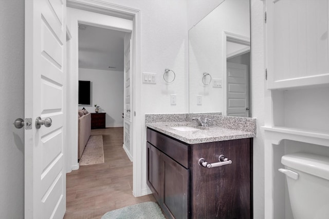 bathroom with vanity, toilet, and wood finished floors