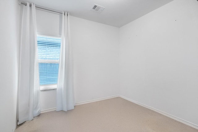 unfurnished room with light carpet, visible vents, and baseboards