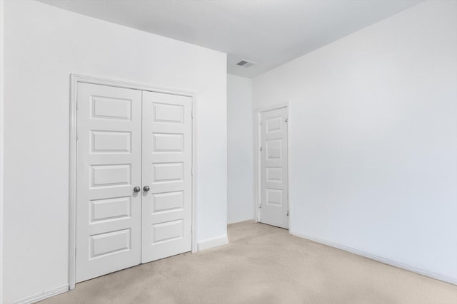 unfurnished bedroom with baseboards, visible vents, and a closet