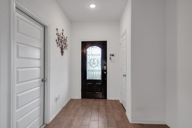 foyer entrance with light wood-style floors and baseboards