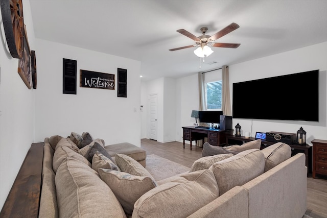 living area with a ceiling fan and wood finished floors