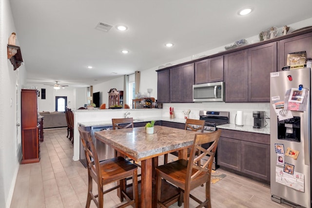 kitchen featuring dark brown cabinetry, visible vents, a peninsula, stainless steel appliances, and recessed lighting