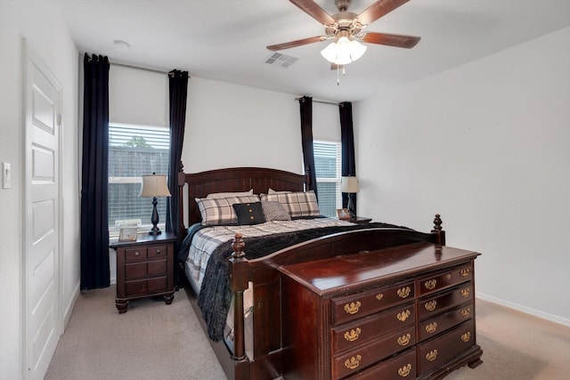 bedroom featuring ceiling fan, multiple windows, visible vents, and light colored carpet