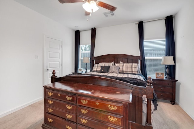 bedroom featuring baseboards, multiple windows, visible vents, and light colored carpet