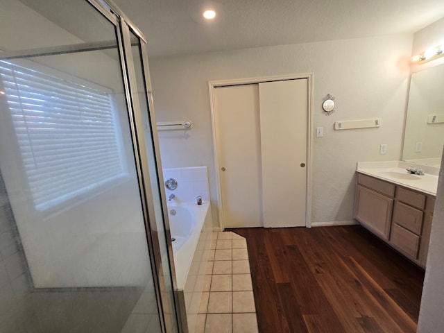 4731 Mohegan Ct, Baytown, TX 77521 - full bath with vanity, wood finished floors, a bath, and a shower stall