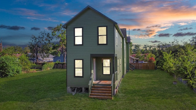 back of house featuring a yard and fence