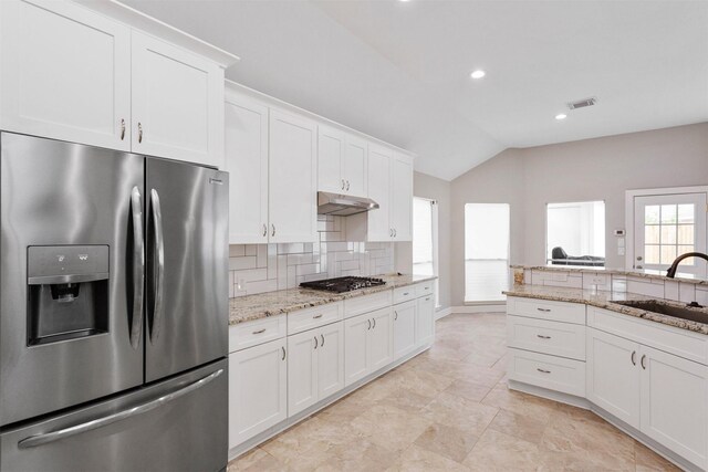 kitchen featuring under cabinet range hood, a sink, visible vents, appliances with stainless steel finishes, and tasteful backsplash