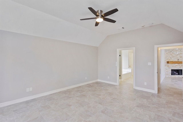 unfurnished room with visible vents, baseboards, a ceiling fan, lofted ceiling, and a fireplace