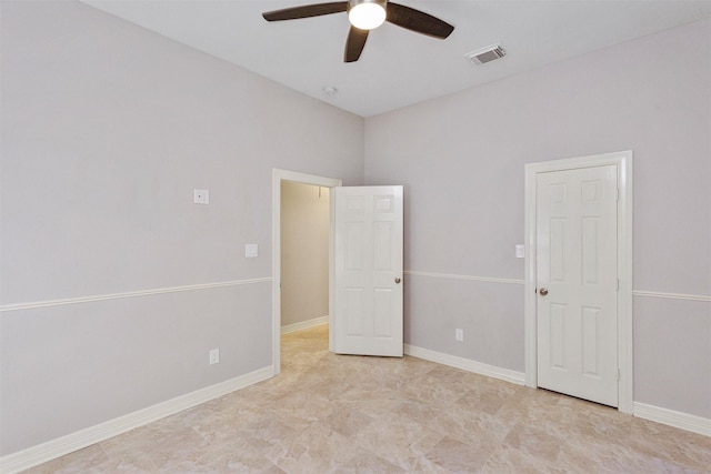 spare room featuring a ceiling fan, visible vents, and baseboards