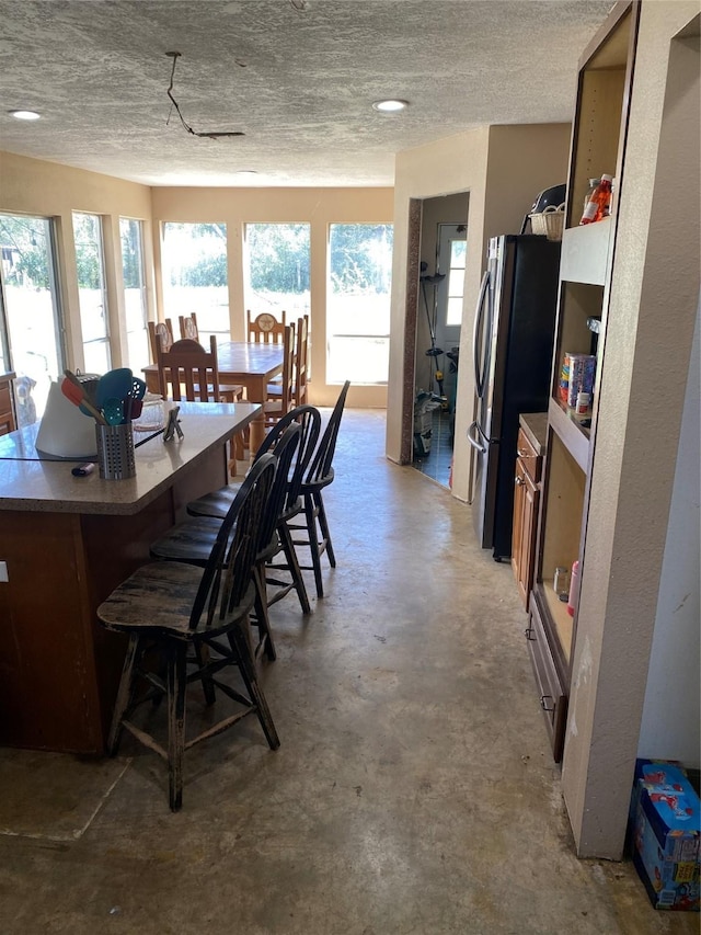 dining space featuring a textured ceiling and concrete floors