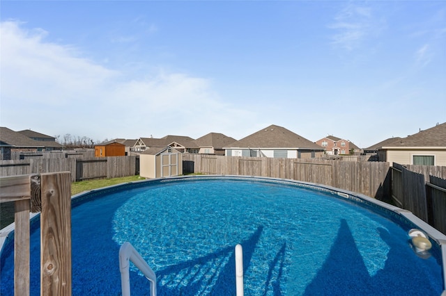 view of pool featuring a fenced in pool, a residential view, a fenced backyard, and a storage unit