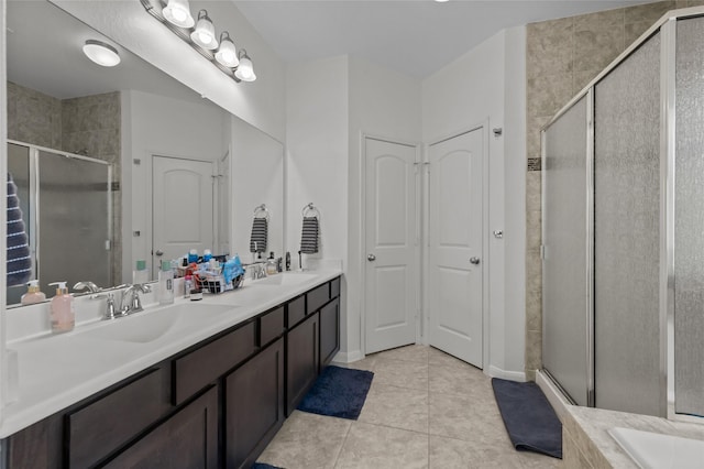 full bath with double vanity, tile patterned flooring, a shower stall, and a sink