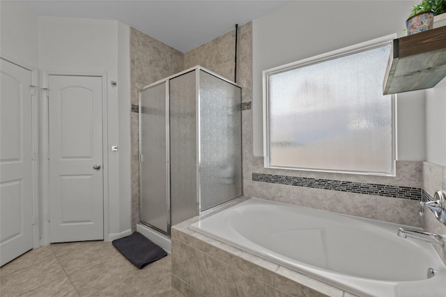 full bathroom featuring a stall shower, a bath, and tile patterned floors