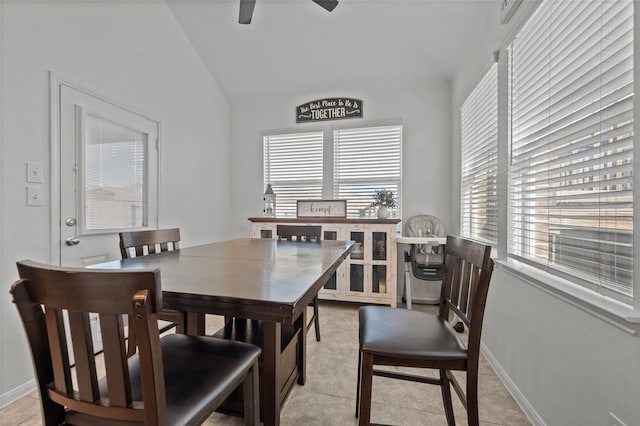 dining area featuring baseboards, vaulted ceiling, a ceiling fan, and light tile patterned flooring