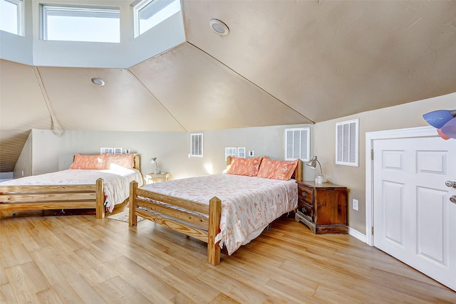 bedroom featuring lofted ceiling, light wood-style flooring, and visible vents