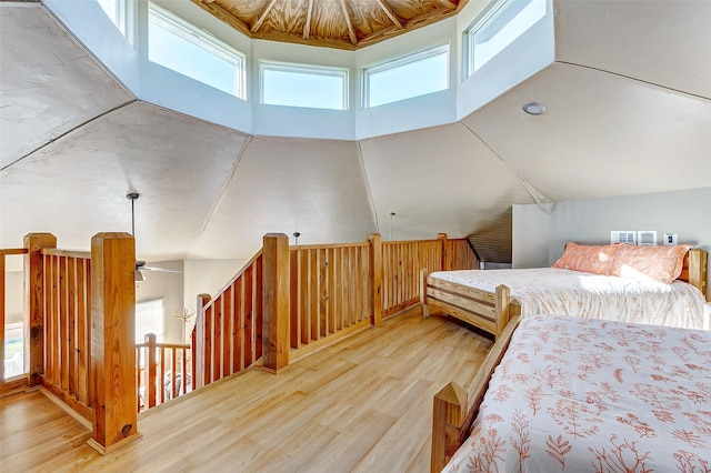 bedroom featuring high vaulted ceiling and wood finished floors