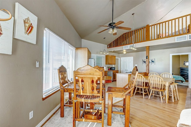 dining room with high vaulted ceiling, visible vents, baseboards, light wood-style floors, and a ceiling fan