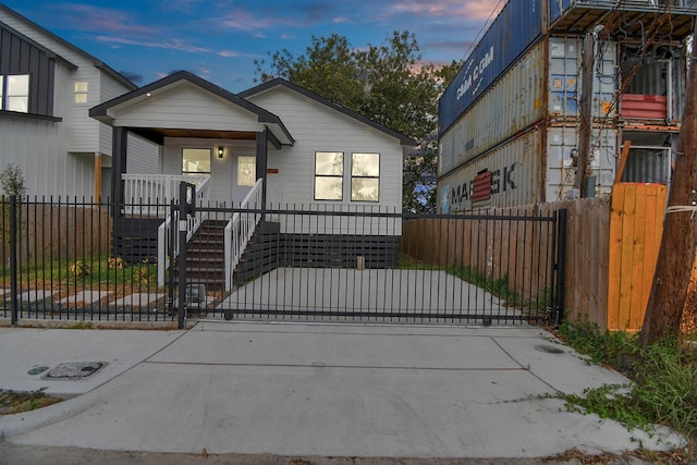 view of front of home with covered porch, a fenced front yard, and a gate