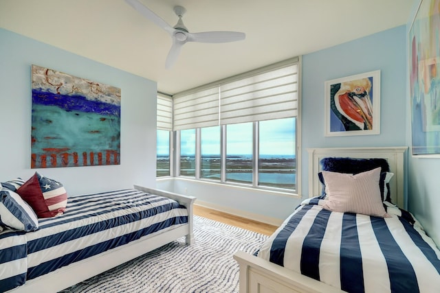 801 E Beach Dr Unit Bc2412, Galveston, TX 77550 - bedroom with wood finished floors, a water view, and a ceiling fan