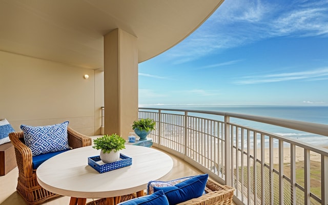 balcony featuring a water view and outdoor dining space